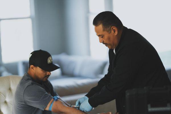 Jerry, a phlebotomist drawing blood in a clients home