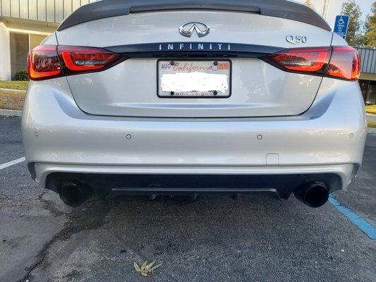 Chrome INFINITI badge wrapped with letters cut out and bottom area of bumper wrapped.