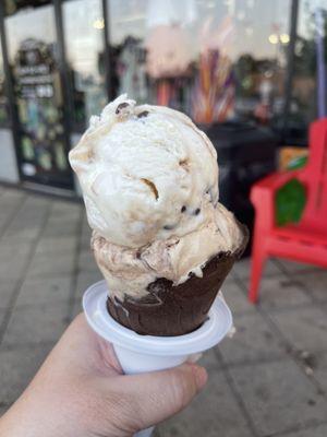 1 scoop of salted caramel on top of 1 scoop of coffee fudge in a dark chocolate cone