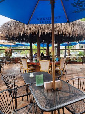 Patio area with a center fire pit and heaters all around.