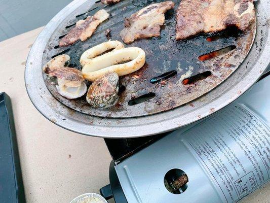 Grilling some garlic butter clams, calamari rings, etc