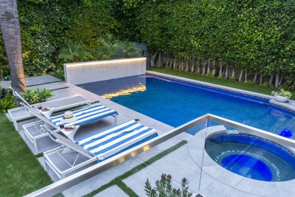 View of the pool, water wall from elevated patio with glass wall.