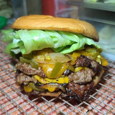 Triple smashburger with grilled onions and Jalapeños