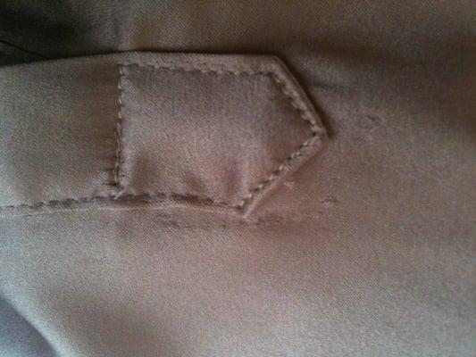 Visible stitch-ripping in the silk, below and to the right; silk is destroyed on the sleeve