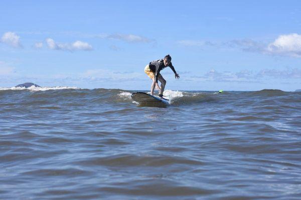 Michael catching waves on his first day surfing!