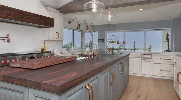 This frameless European style kitchen features contrasting glazed finishes, panelized appliances, and a walnut butcher block countertop.