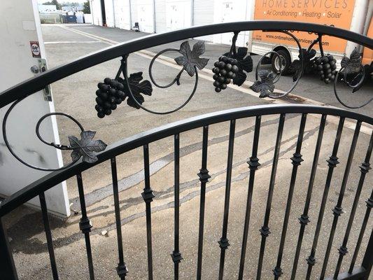 More grapes with vines on a pedestrian gate.