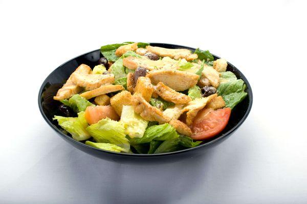 Chicken Caesar Salad from Genova's To Go: Fresh greens, tomato, grilled chicken, and creamy Caesar dressing.