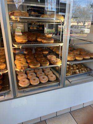 Display case of donuts and bagels offered by business.