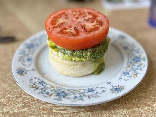 Crumpet with fried egg, with pesto, mozzarella and tomato