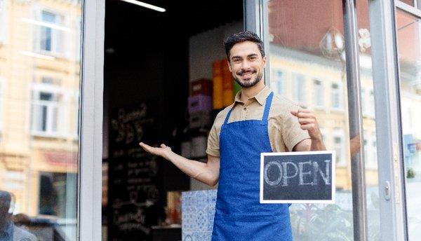 Business owner holding open for business sign