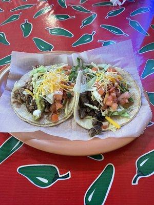 Carnitas supreme taco and a steak regular taco