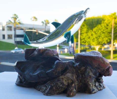 Glass dolphin atop manzanita.