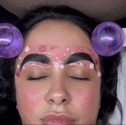 Client enjoying a relaxing jelly mask while her brows are staining