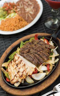 Fajita Combo Grilled certified angus steak, fresh grilled chicken, served with refríes beans, rice, guacamole, pico