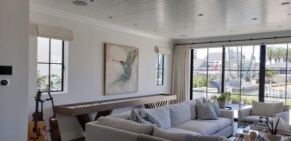 Custom roman shades and white drapery on rod and rings. living room