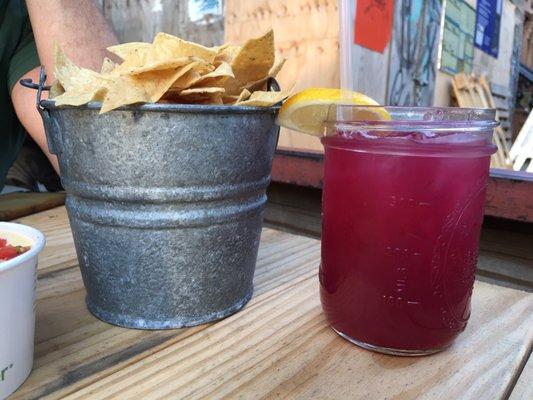 Overflowing bucket of tortilla chips, and a berry fresh lemonade served in a Ball jar