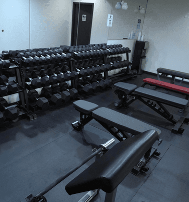 Dumbbell room with plenty of dumbbells, benches, and a preacher curl