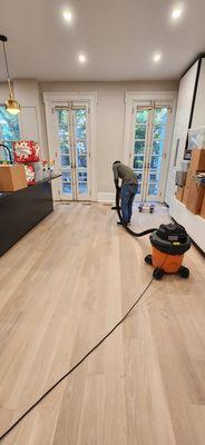 Vacuuming floor to remove dust