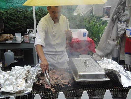 Chef from Bistro Liason booth workin the lamb.