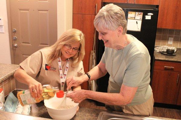 Caring Senior Service caregiver helping client make dessert