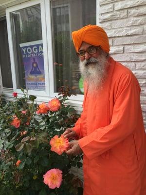 The senior monk Dada Shankarananda - happy with the flowering roses at our entrance.