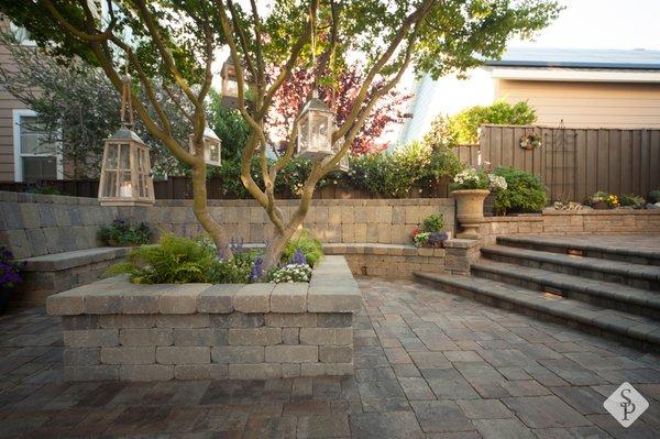 Sunken paver patio, custom planter, seating area and stairs. (all completed using paving stones)