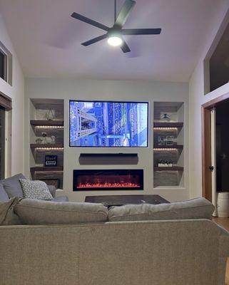 The finished room! Stone wall accents, fancy fireplace, custom shelves and smart home lighting!