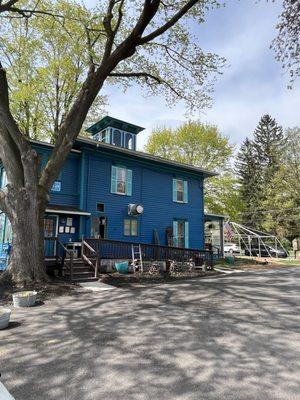 Big blue house with some parking on the side.