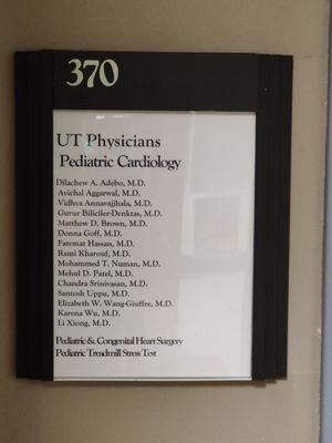 Signage at left of door entrance with suite number, place name, and a list of doctors