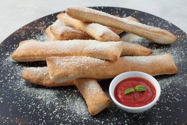 Our freshly made breadsticks, come in 8 pieces sprinkled with parmesan cheese and a 
 free house marinara sauce (or any dip).