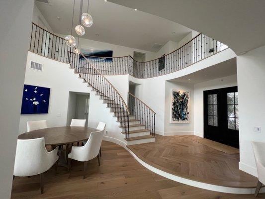 Hardwood floors, custom nosing, herringbone pattern in foyer, custom stair treads and handrail.