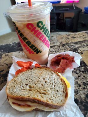 Sourdough sandwich, sack of bacon, iced coffee