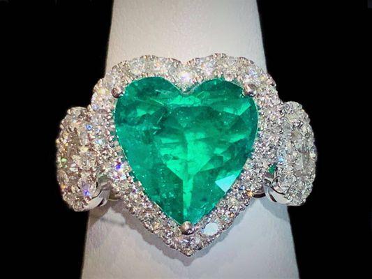 Emerald heart surrounded by diamonds in white gold setting