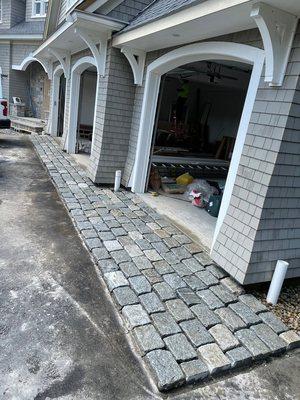 custom stone inlay between driveway and garage: after