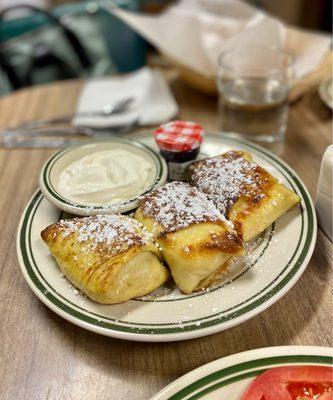 Piping-hot housemade blintzes with sour cream and raspberry preserves, mind-blowing.