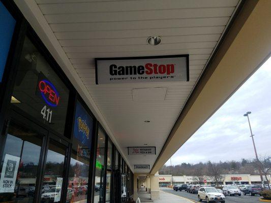 A GameStop sign, next to the storefront.