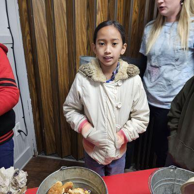 J helping out at dinner and weighing food waste.