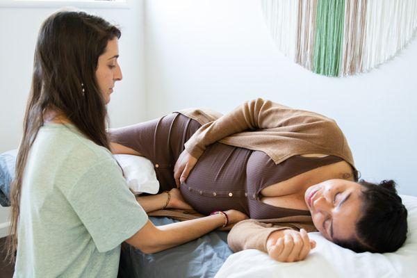 A pregnant woman receiving osteopathic treatment to prepare her for a more easeful birth.