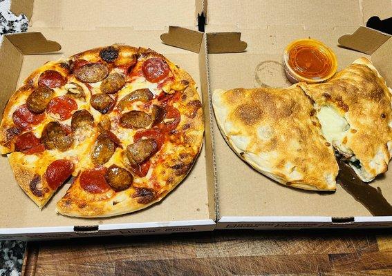 Small sausage, pepperoni and garlic pizza and a stuffed calzone