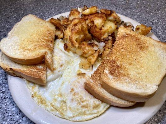 Two eggs over easy, sourdough bread and potatoes