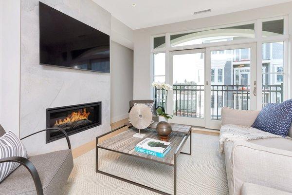 Living/ Family room with linear fireplace and private balcony at Vue New Canaan in New Canaan, Connecticut.