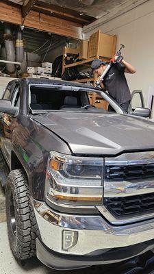 Expert technician laying the urethane adhesive before setting the new windshield.