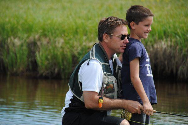 Kirk teaching his son to fly fish in Yellowstone