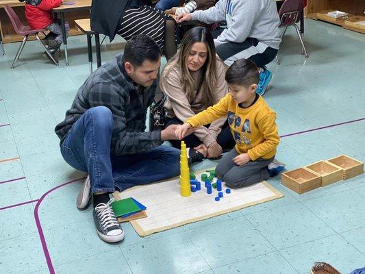 Primary student showing parents block-stacking skills and size recognition.