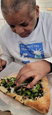 Customer enjoying a veggie slice at pizza shop in the Bartow Mall  Co-Op city Bronx NY