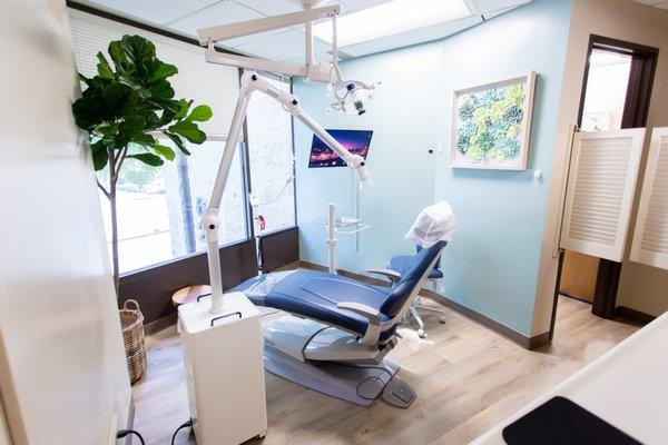 Treatment room with extra oral unit capturing airborne particles.