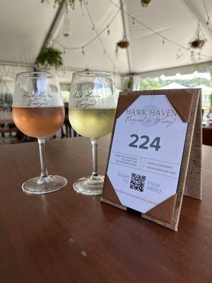 Glass of sparkling rose and glass of Albariño on table under patio tent