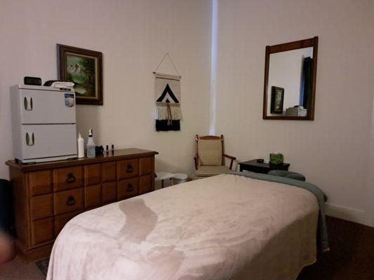 Massage therapy table with cozy blanket, towel warmer cabinet