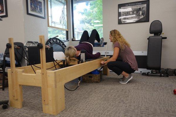 Becky is working with a patient on the Pilates reformer.